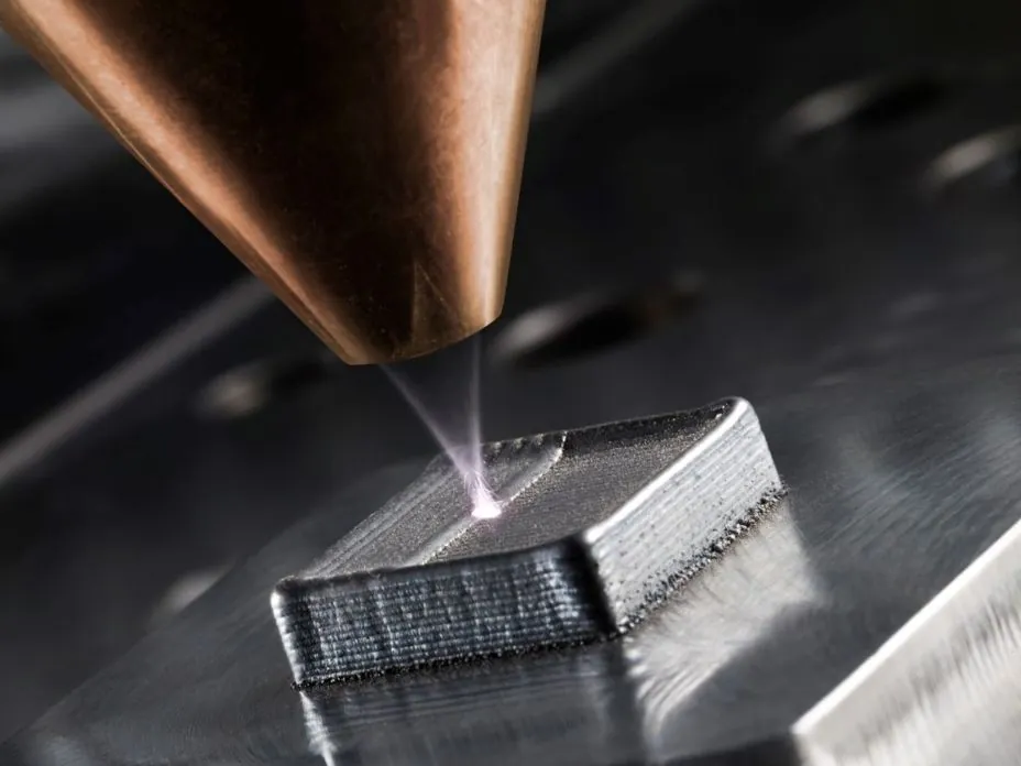 Laser metal deposition nozzle building up a metal part