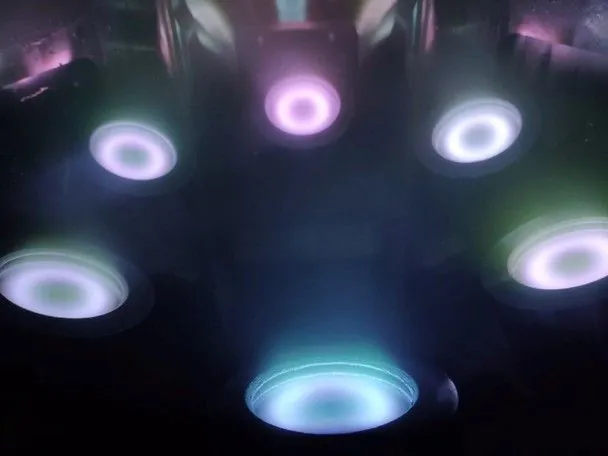 Plasma glowing above several sputter targets inside a deposition chamber