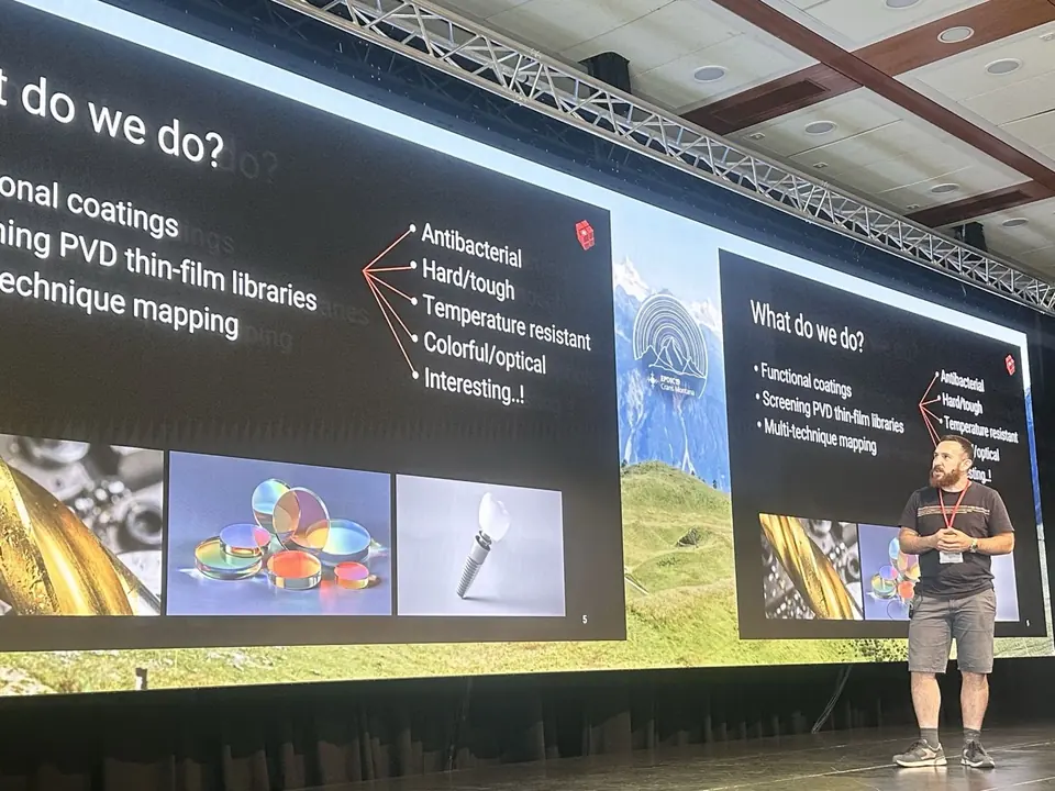 Remo Widmer on stage at EPDIC19 beside a slide titled “What do we do?”